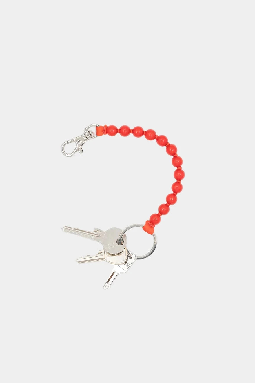 Keychain with red beaded extension and keys on a white background