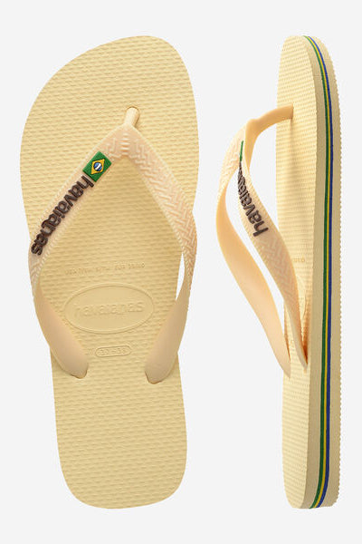 Beige flip-flops with brand logo on a white background