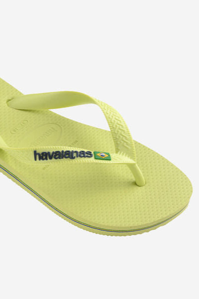 Pair of lime green flip-flops with brand logo on a white background