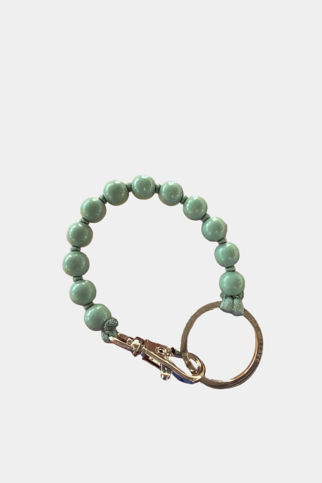 Green wooden beaded keychain on a white background