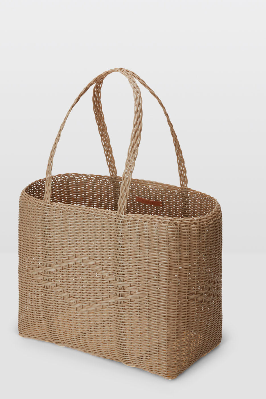 Woven brown tote bag on a light gray background
