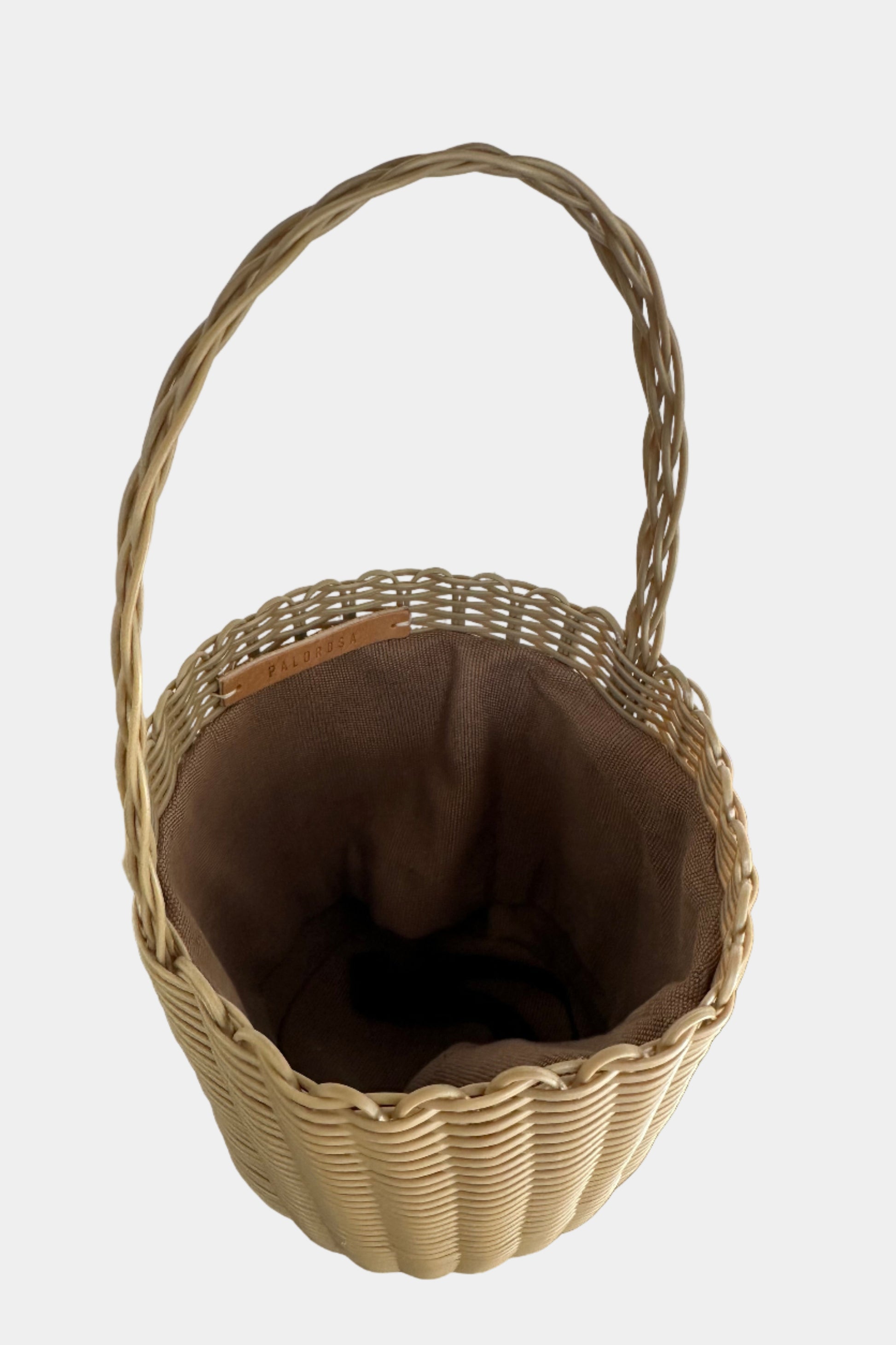 Woven basket with a brown interior on a white surface