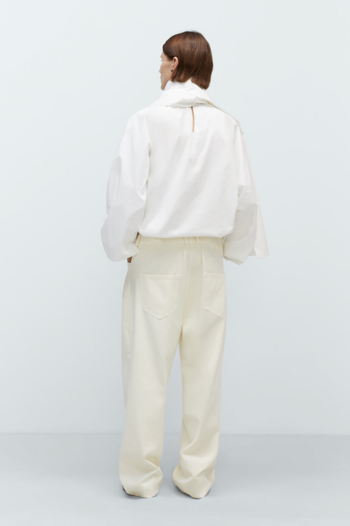 Person wearing a white outfit on a plain background