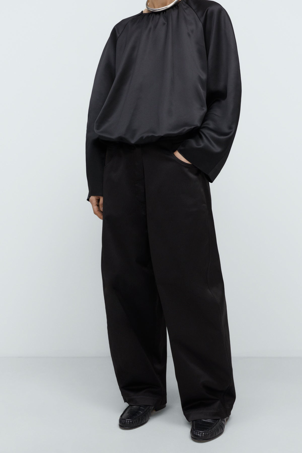 Person wearing a black outfit on a white background