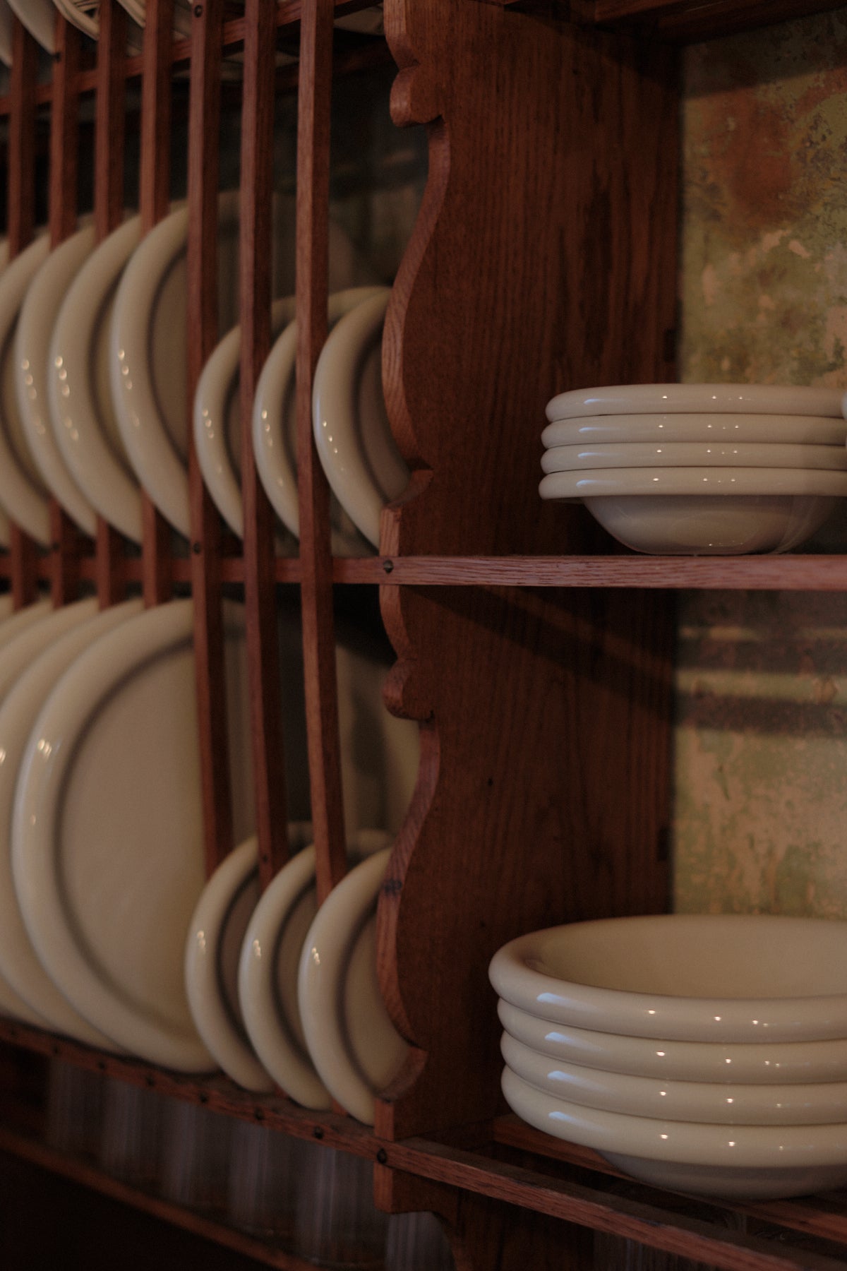 assortment of softedge Marshmallow plates and bowls displayed in a wooden plate rack