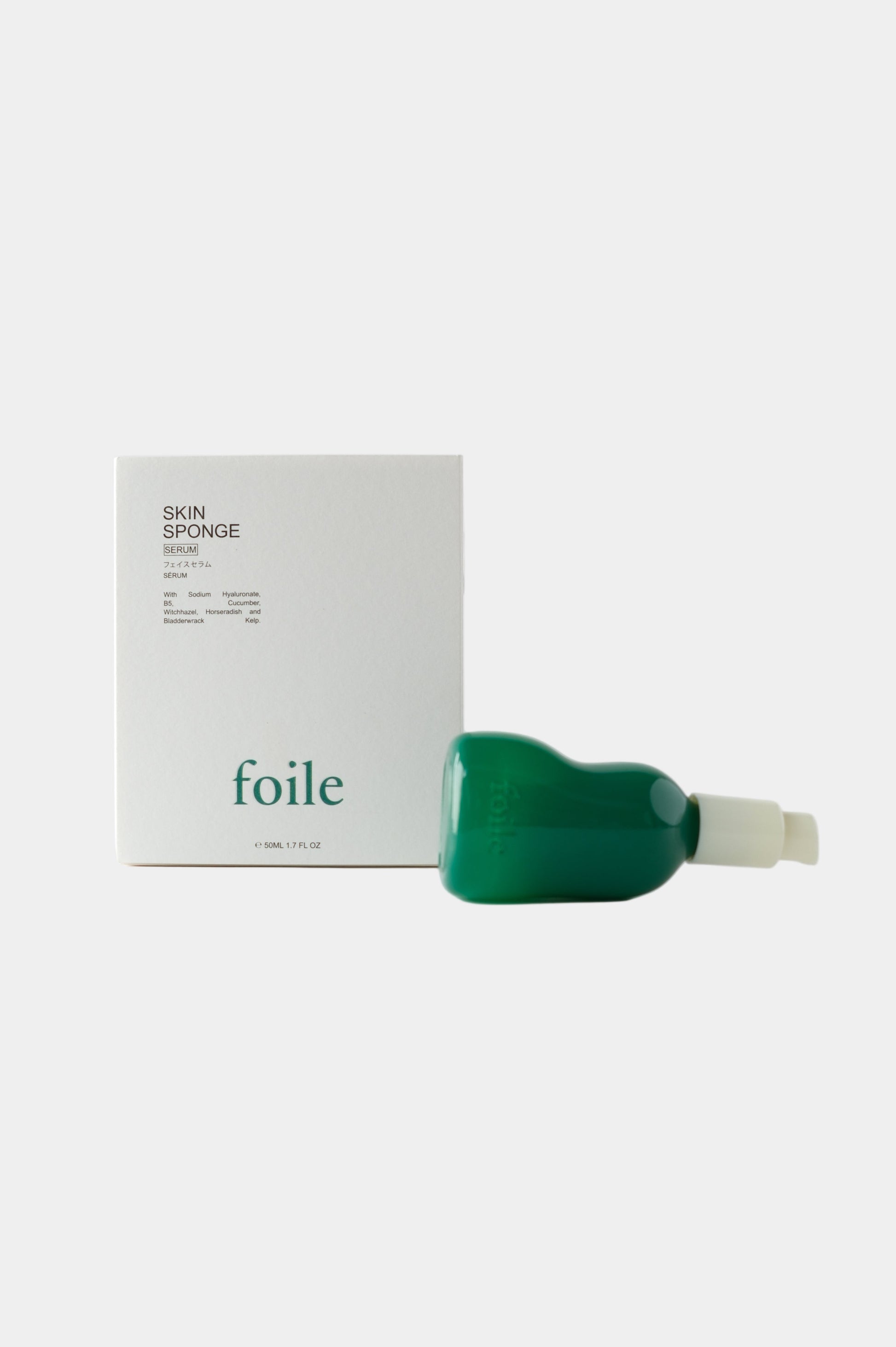 Skin Sponge Serum displayed in green bottle with white box on a light grey background