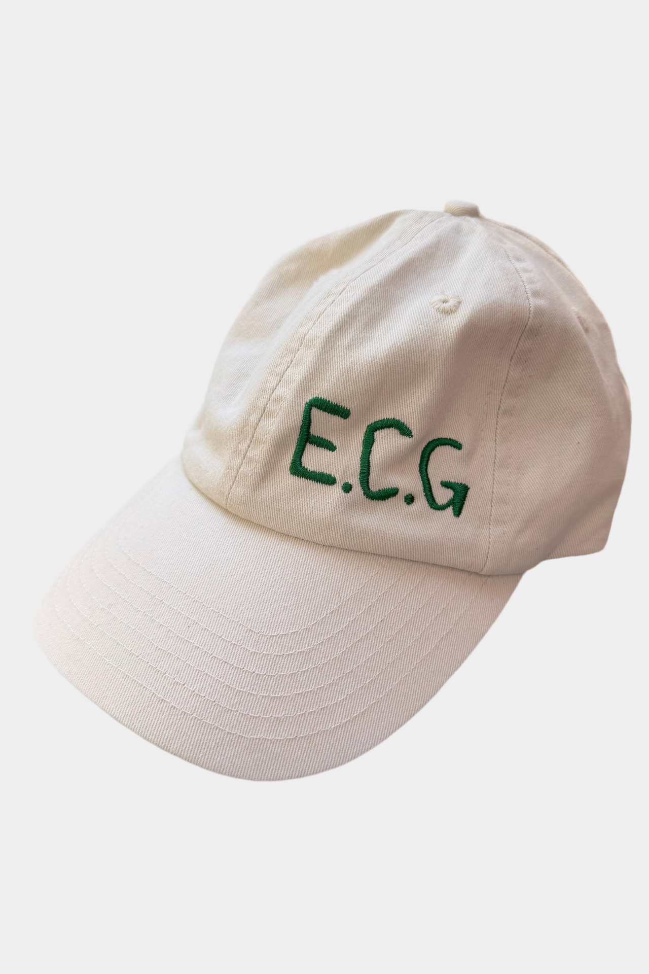 Off white cap with 'E.C.G.' in green on a white background