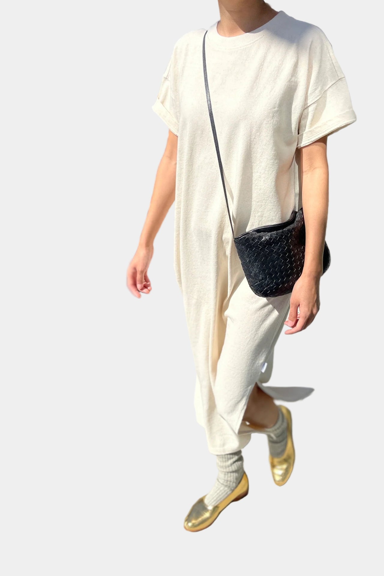 Beige dress hanging on a wooden hanger against a white wall