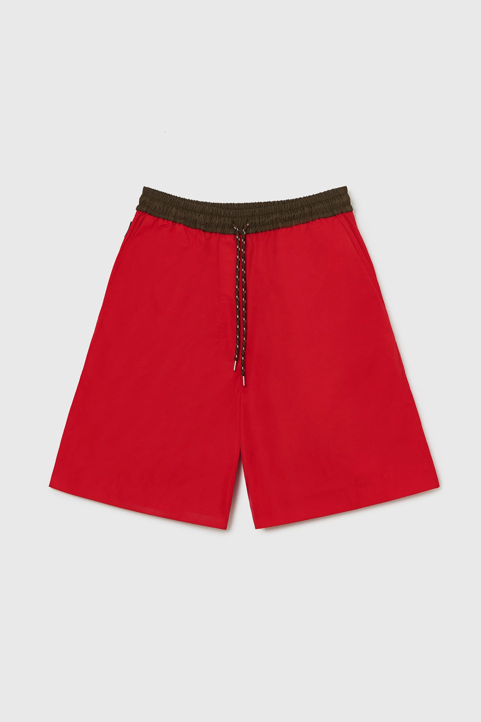 Red shorts with a brown waistband on a light gray background