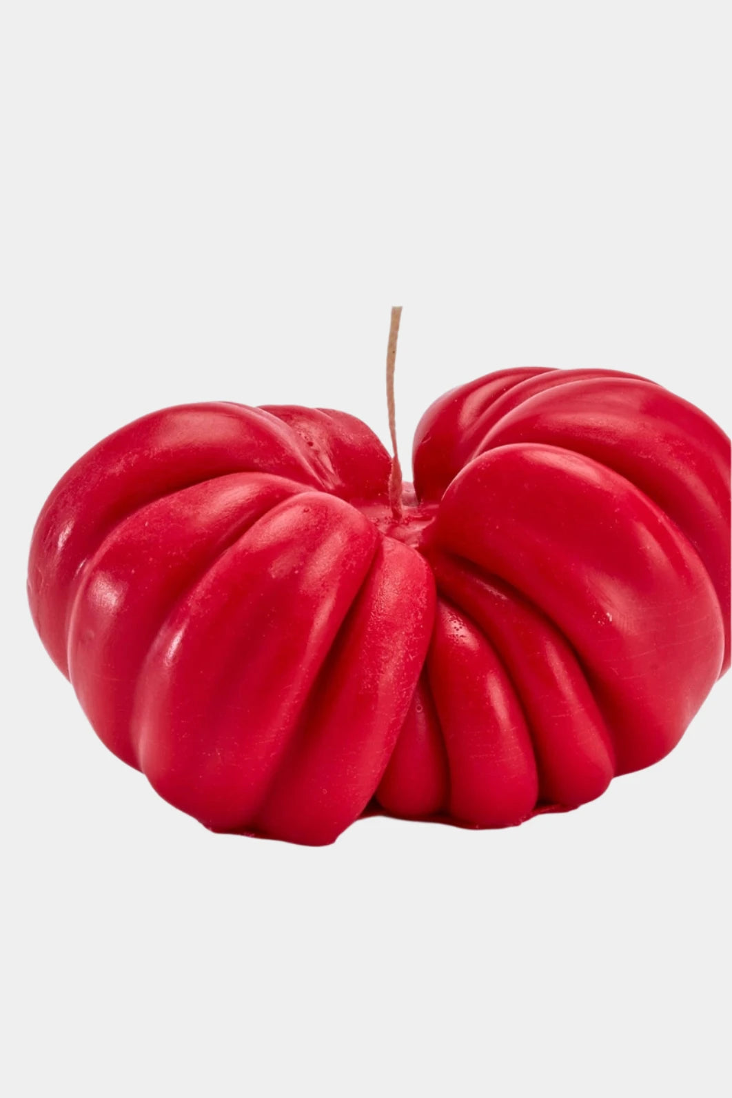 Heirloom red tomato candle on white background