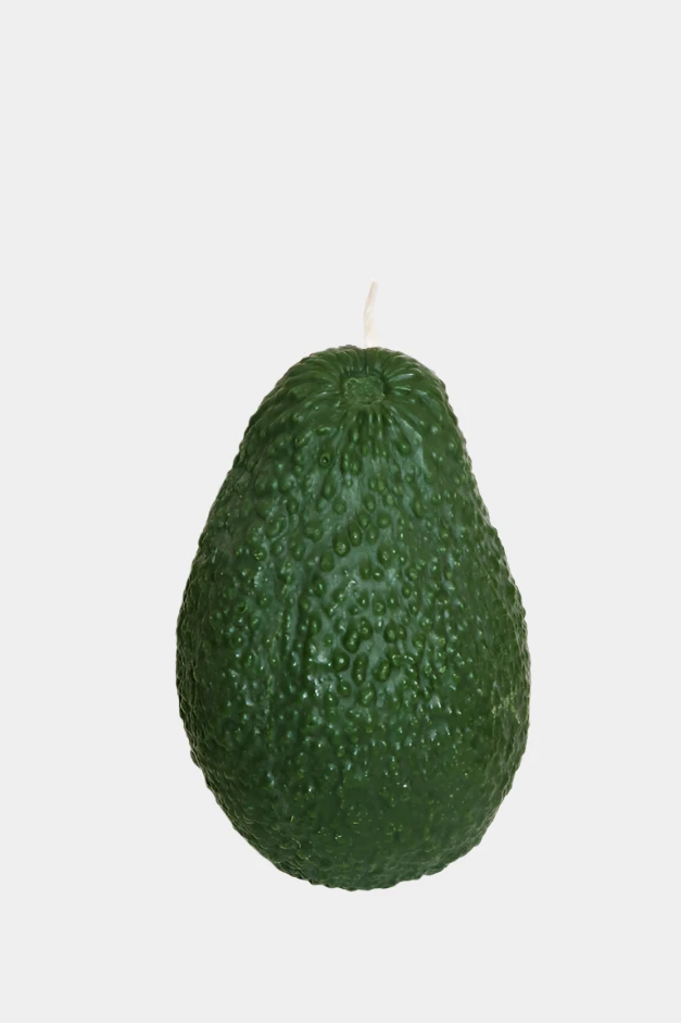 Green avocado candle on a white background