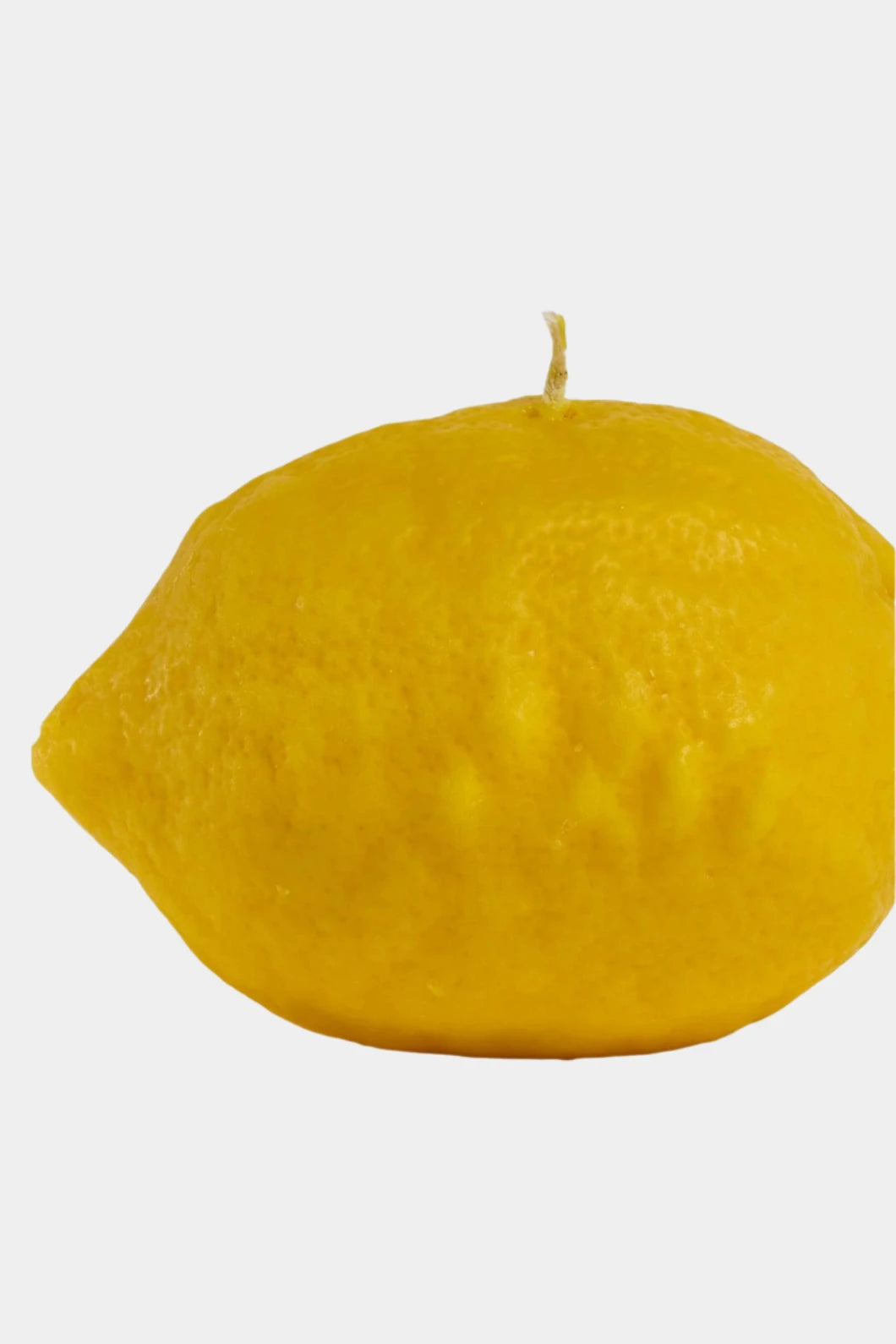 Yellow lemon-shaped candle on a white background