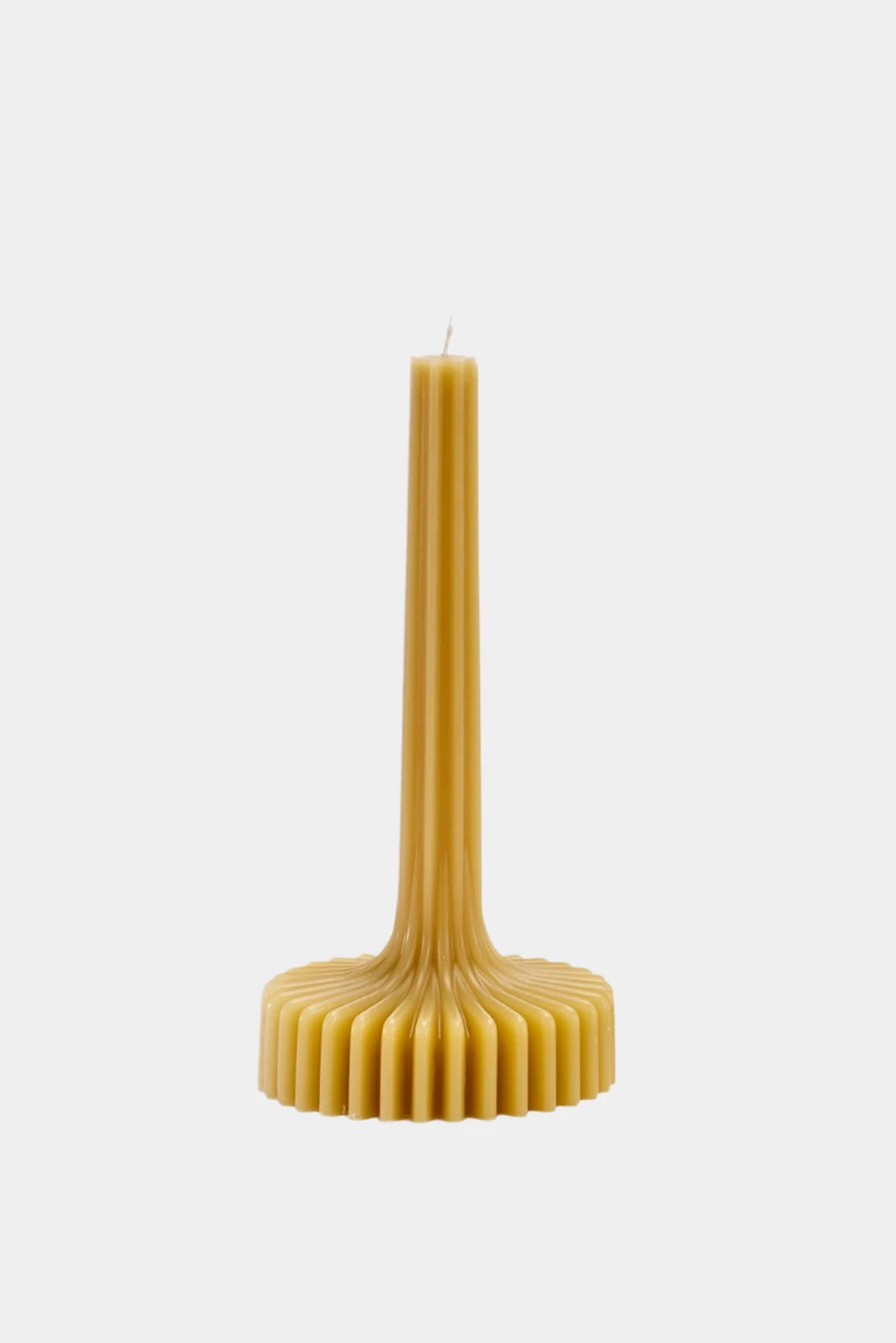 Ribbed beeswax candle on white background.