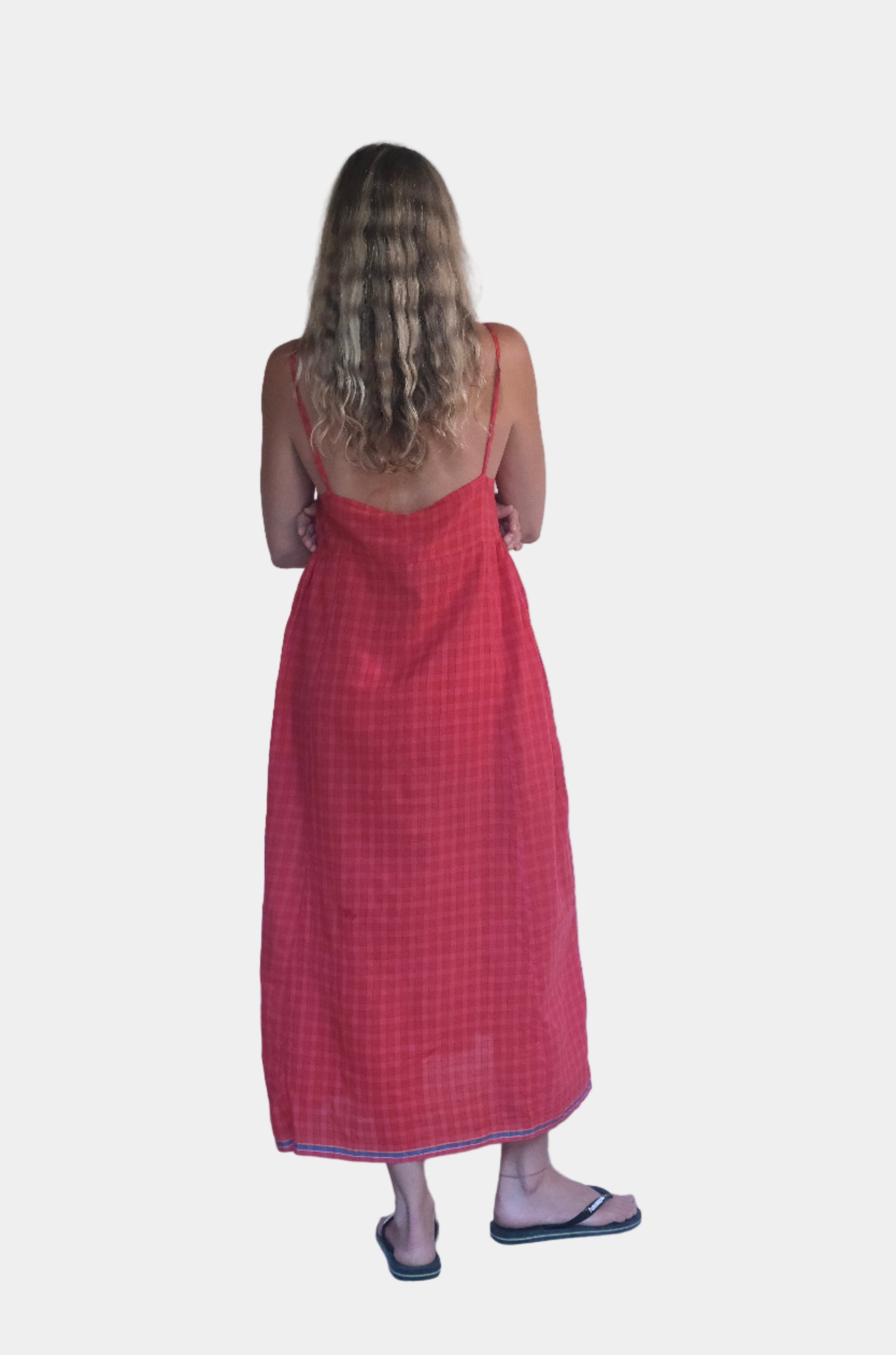 Person wearing a red dress standing against a white backdrop