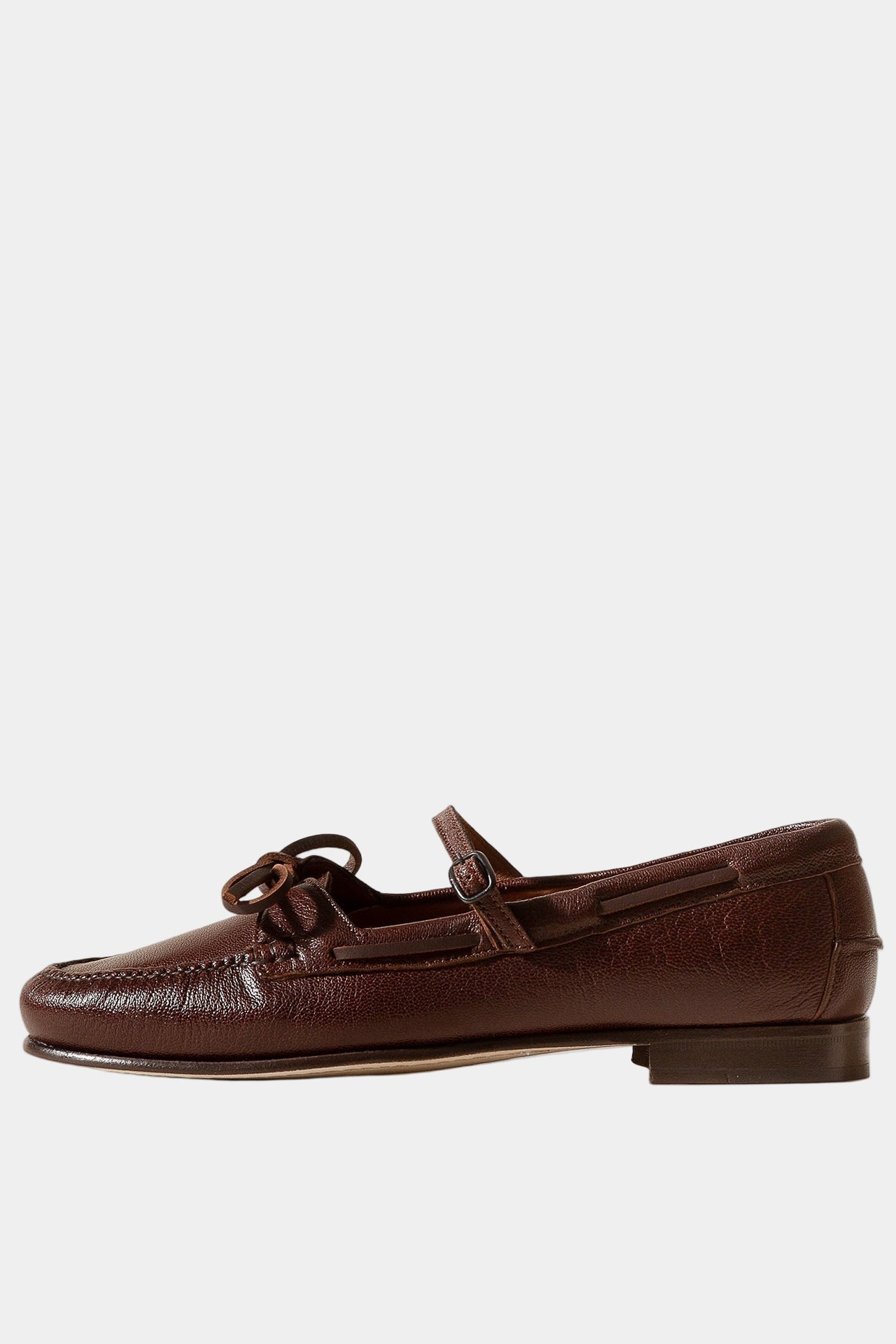 Pair of brown loafers with a brand logo on a beige background