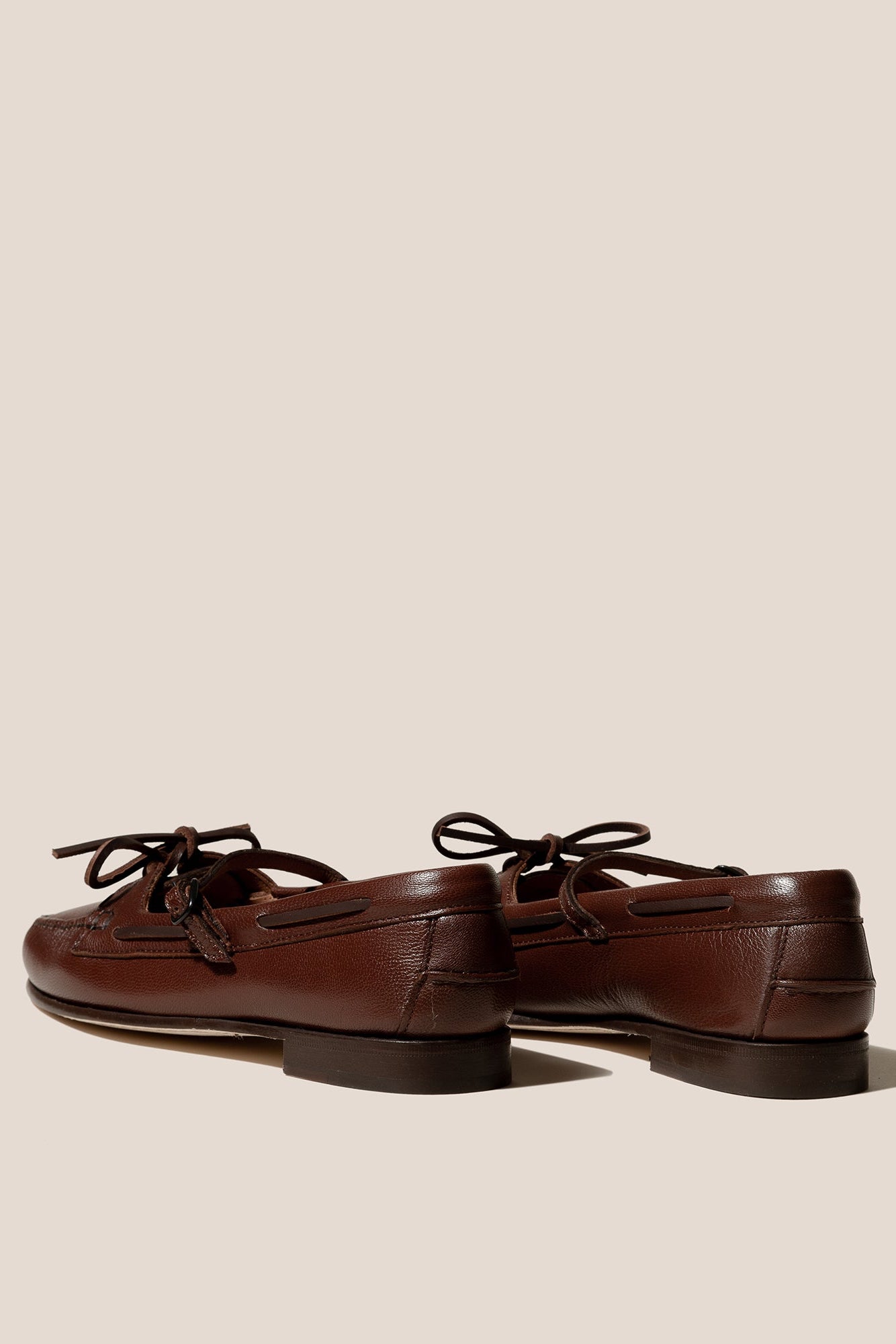 Pair of brown leather loafers on a beige background