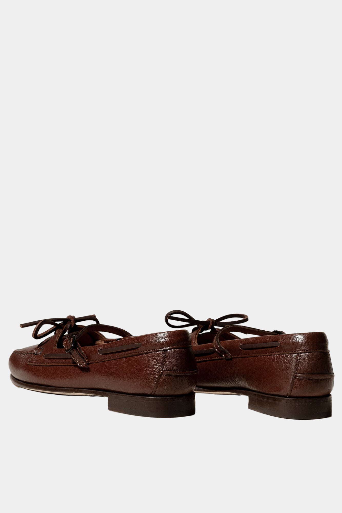 Pair of brown leather loafers on a white background