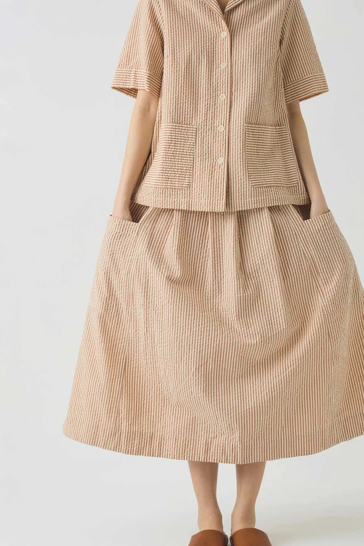 Matching stripe shirt and skirt outfit on a white background