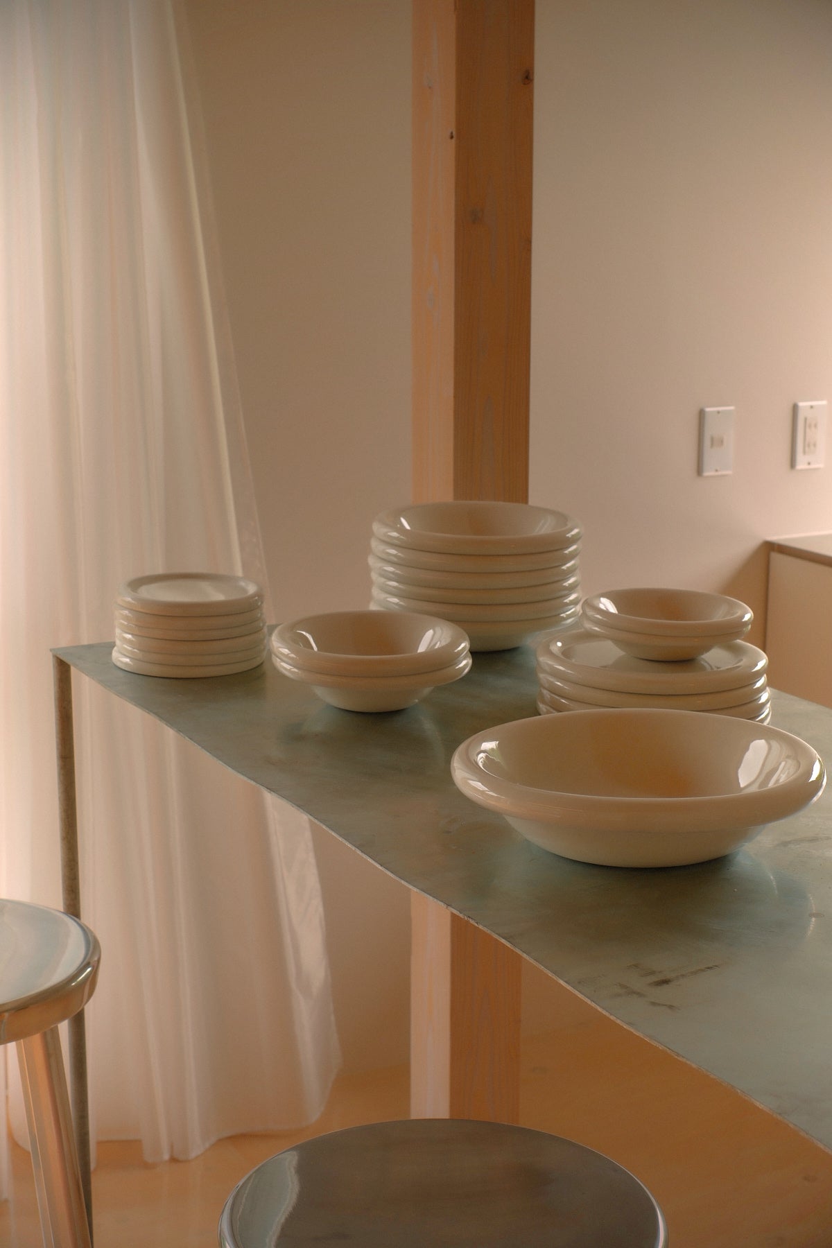 stacks of softedge marshmellow bowls and plates on a stainless steel table
