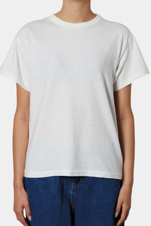 a women wearing a white t-shirt and blue jeans against a plain background