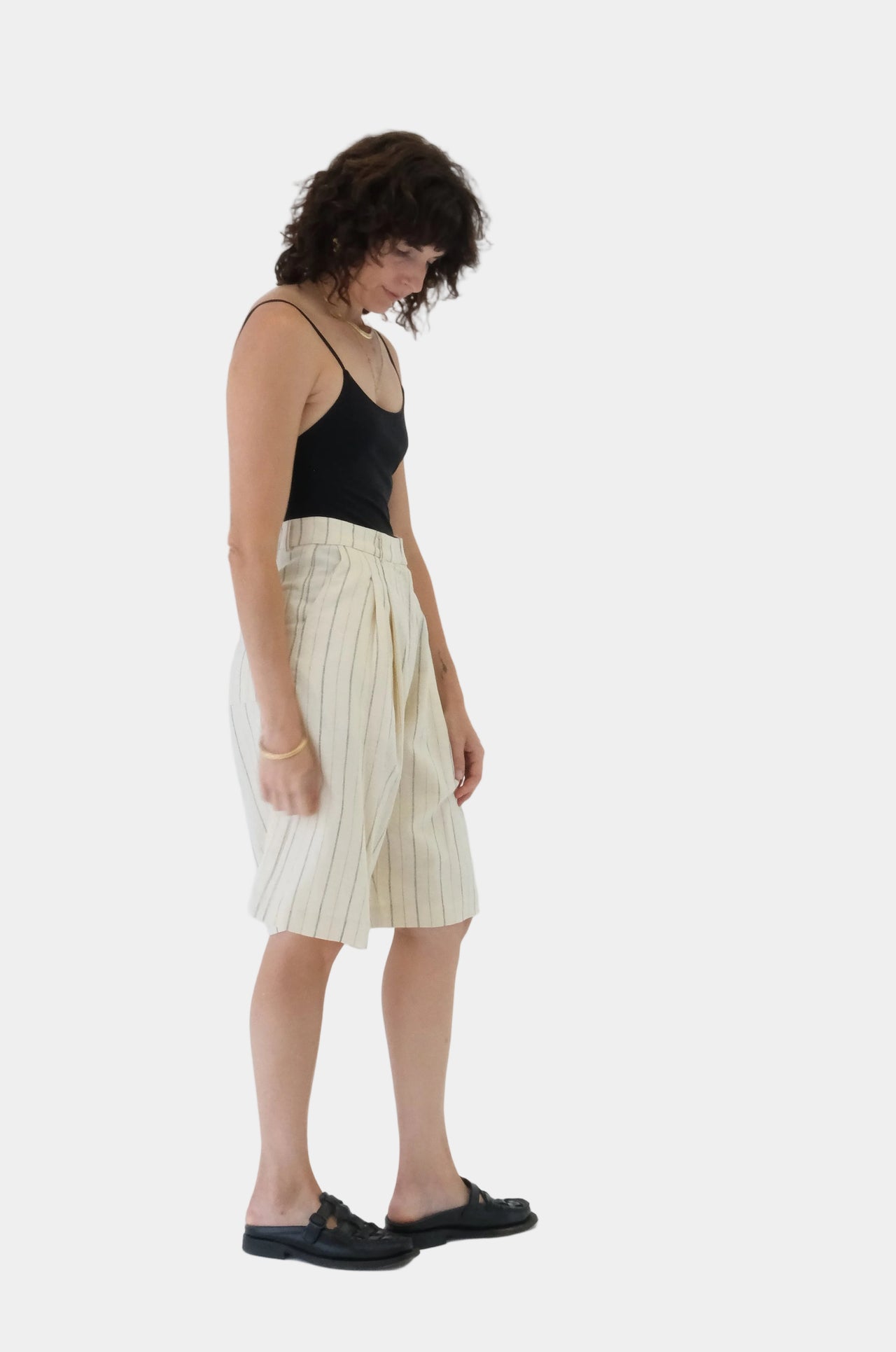 Woman wearing a black top and cream skirt on a white background