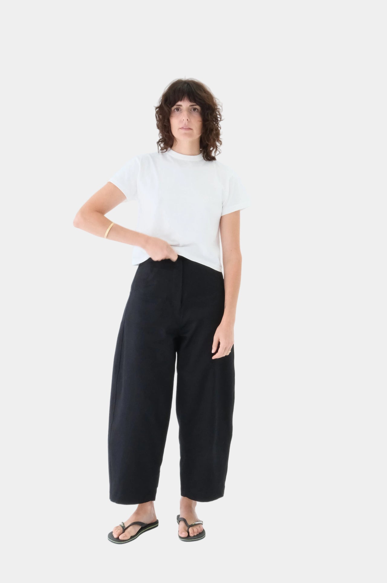 Person wearing a white t-shirt and black pants on a white background