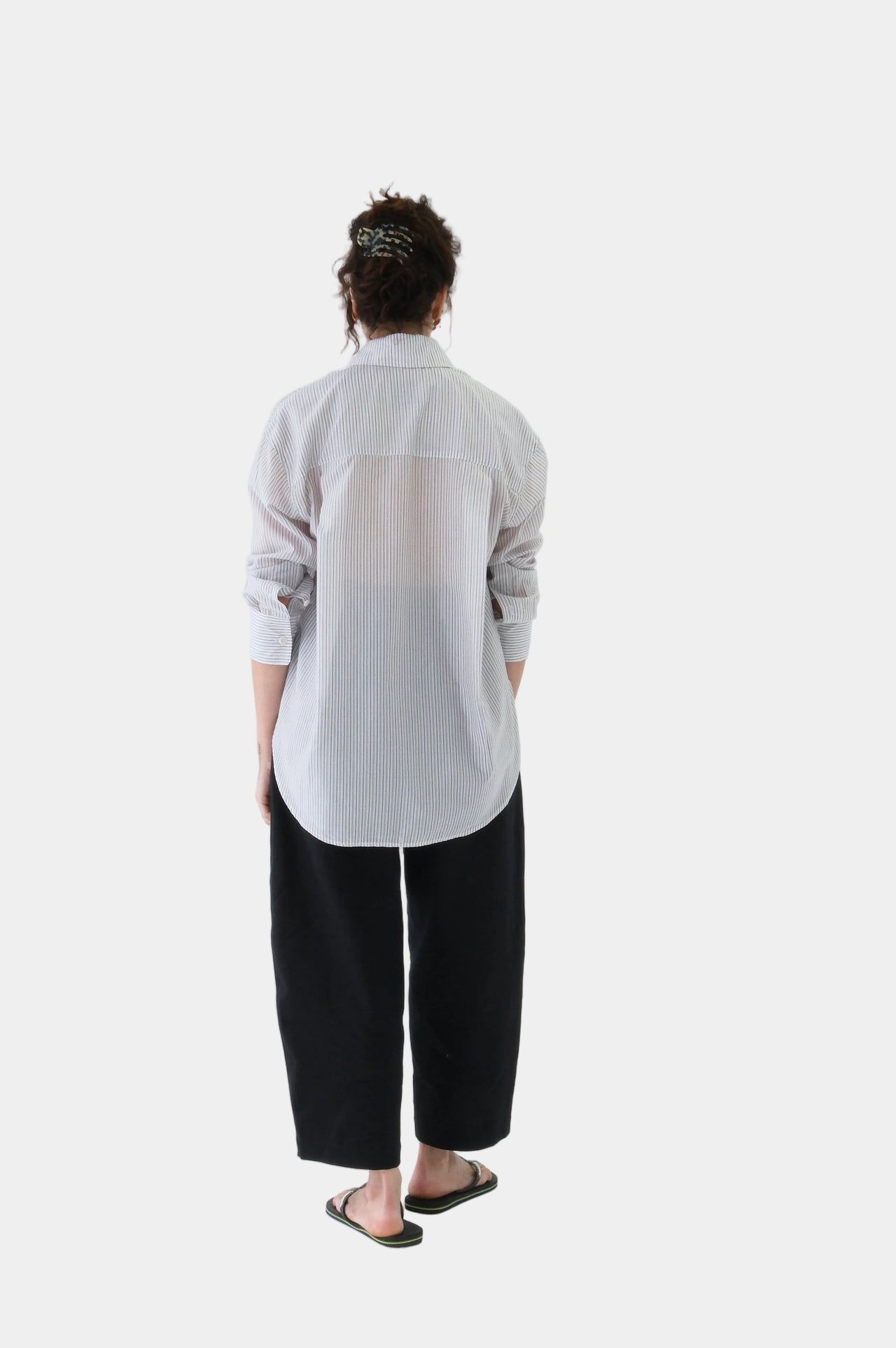 Person wearing a white t-shirt and black pants on a white background
