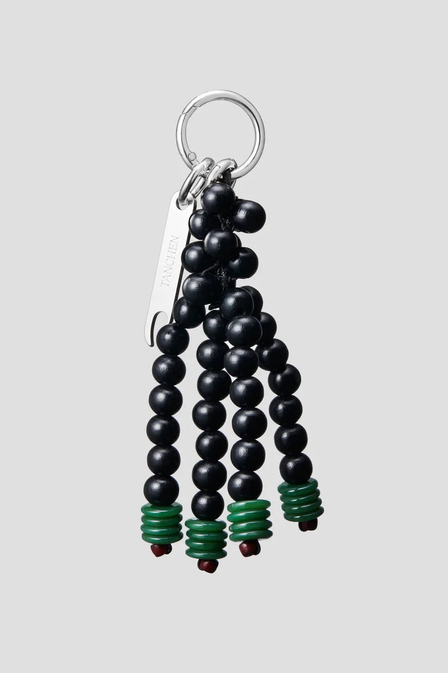 Black beaded keychain with green accents on a gray background