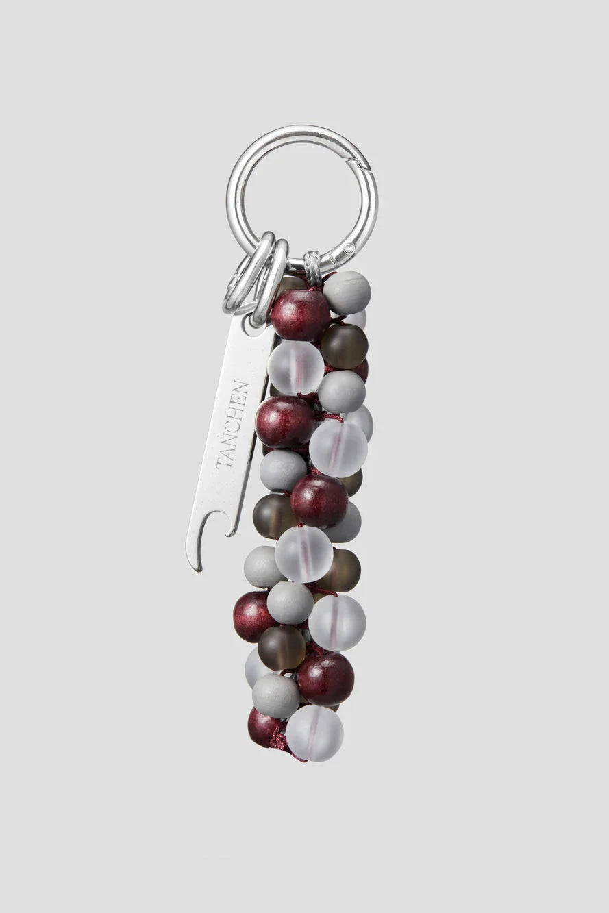 Keychain with beads and a bottle opener on a light gray background