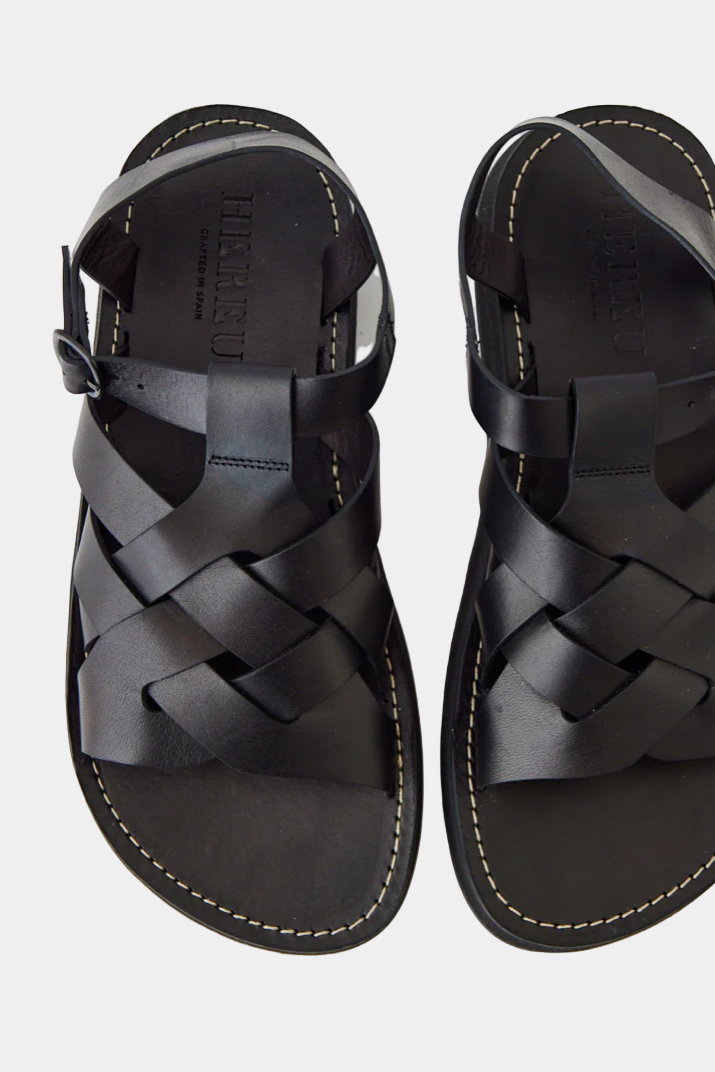 A pair of black open-toe fisherman sandals with straps and a buckle closure.