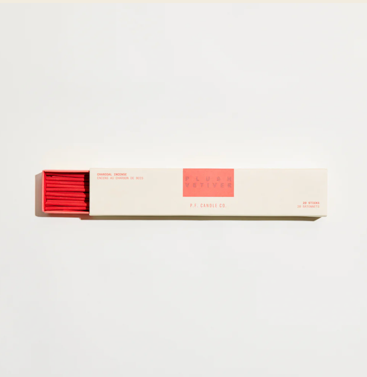 A pack of red incense sticks next to its packaging box with a minimalist design.