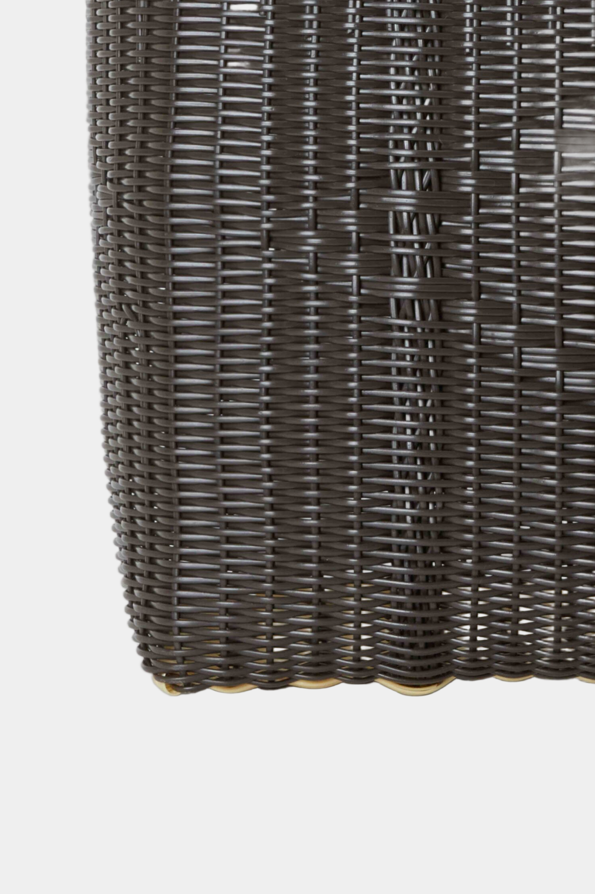 Close-up of a woven dark brown basket on a light gray background