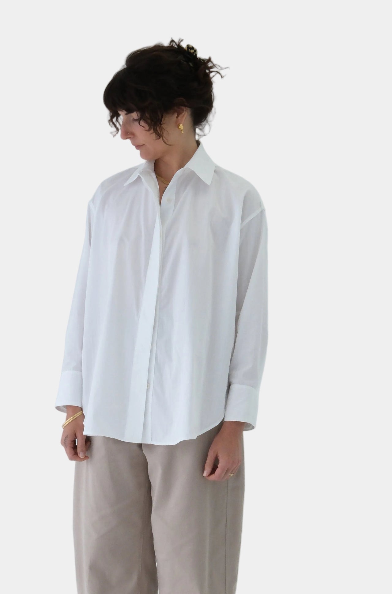 Person wearing a white shirt and beige pants on a light gray background