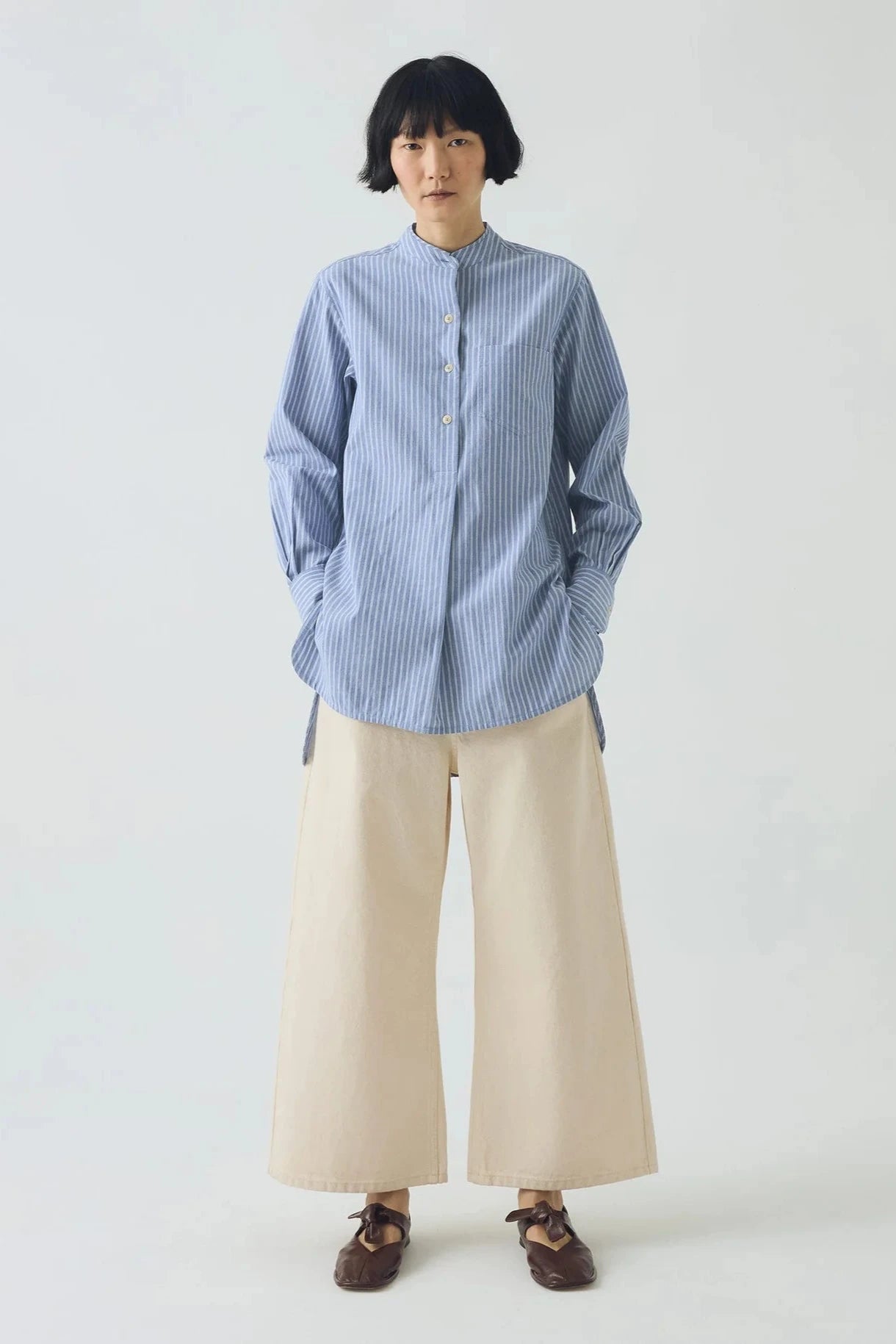 Blue and white striped shirt on a light gray background