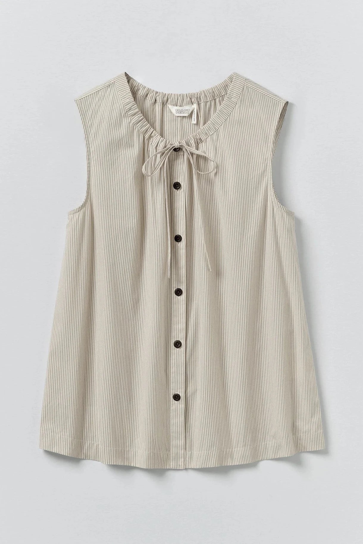 Beige sleeveless blouse with buttons on a light gray background