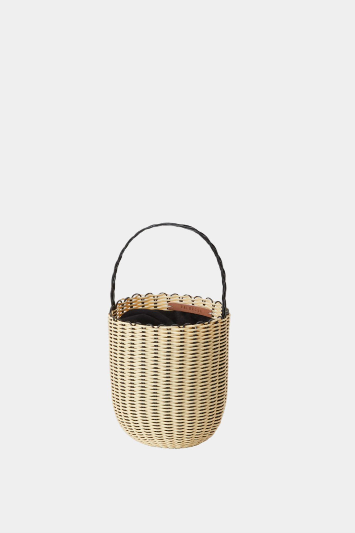 Woven basket with a handle on a light gray background