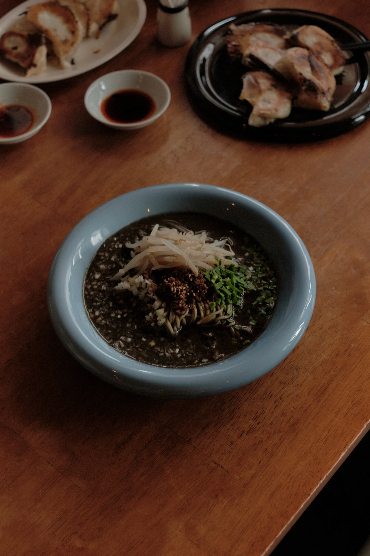 Bowl of soup with toppings on a wooden table