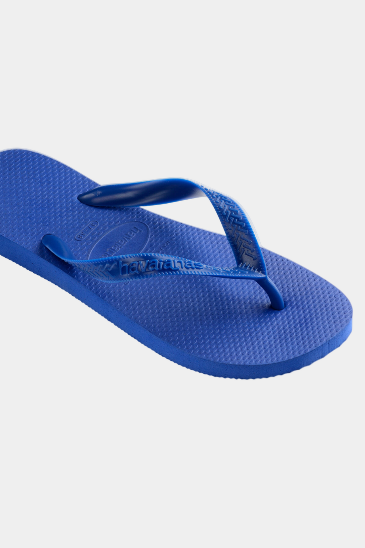 Pair of blue flip-flops on a light gray background