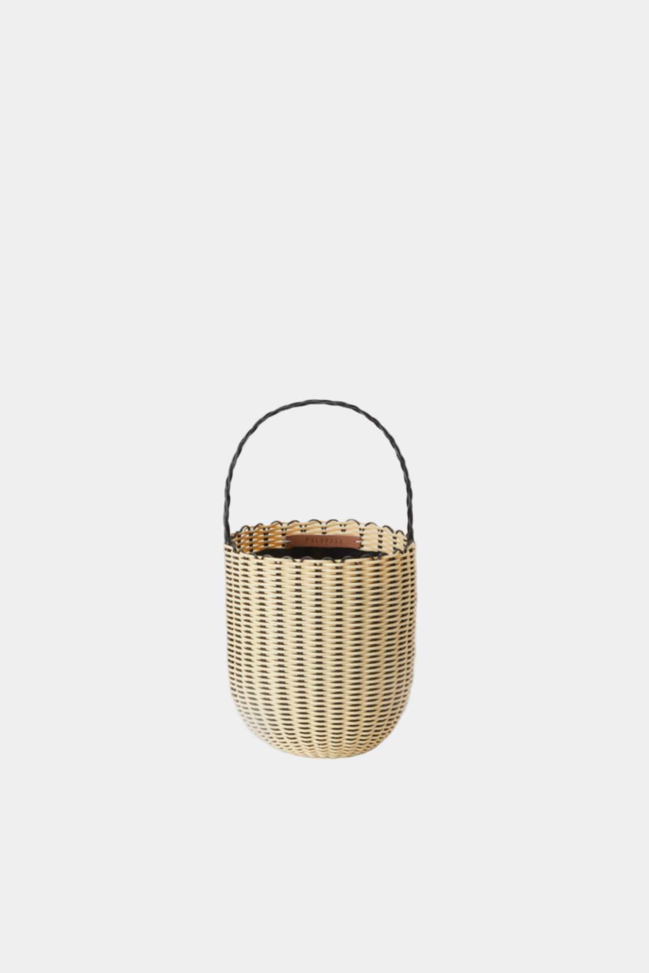 Woven basket with a handle on a light gray background