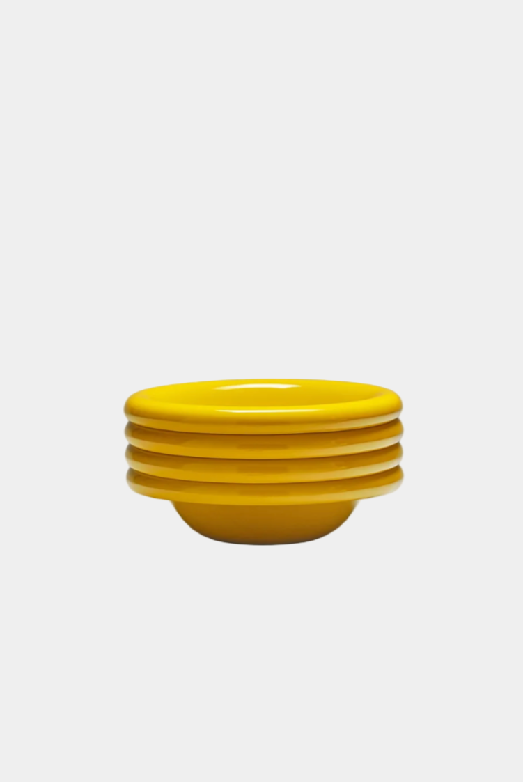 stack of mustard coloured breakfast bowls, on a white background, viewed from the side