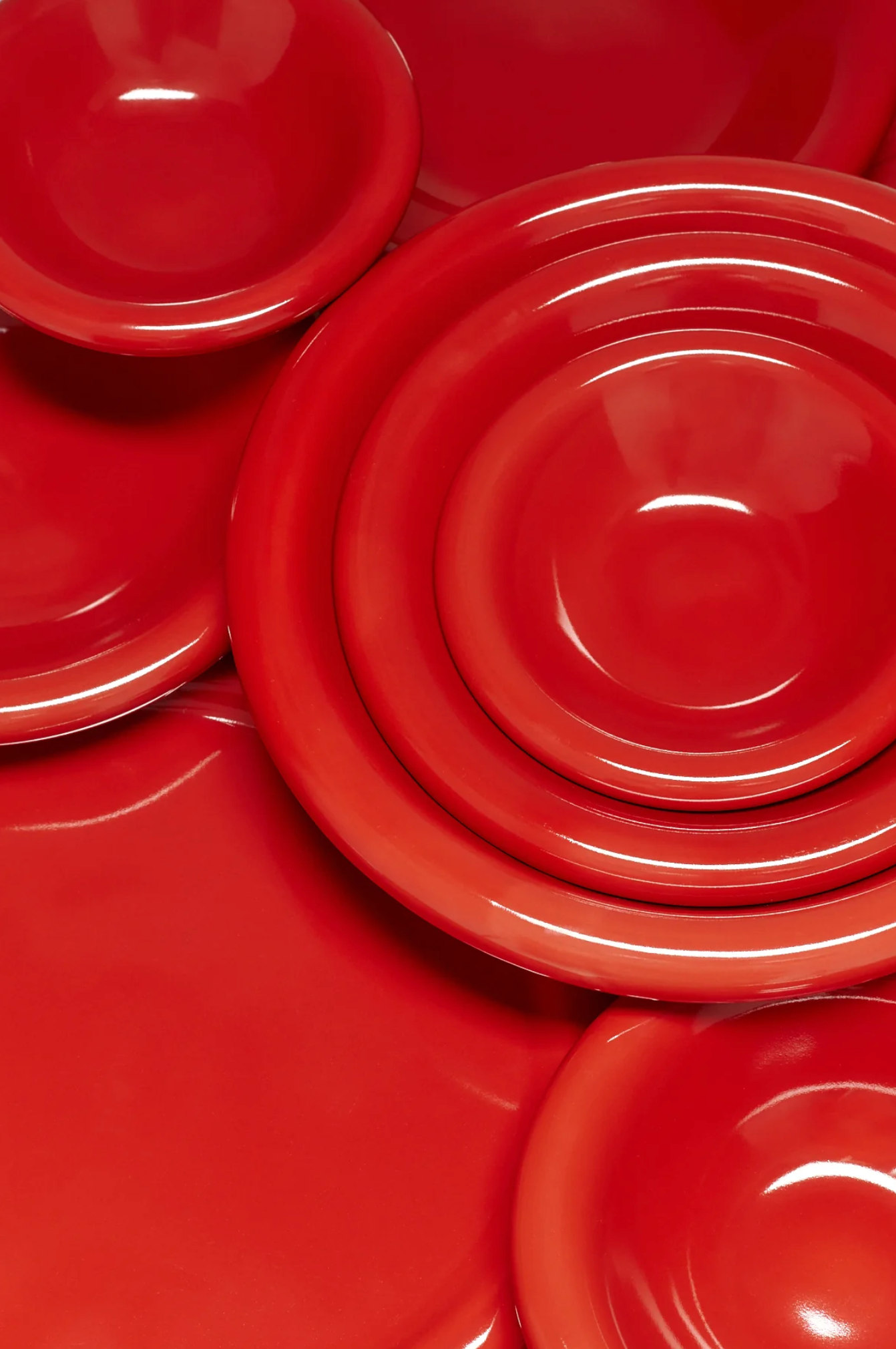 Stack of red ceramic plates and bowls