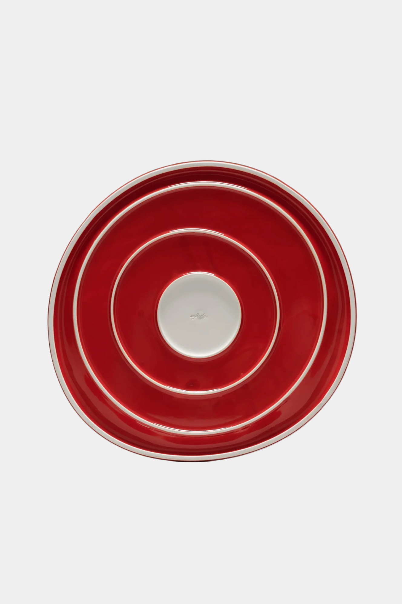 Red ceramic plate with concentric circles on a white background
