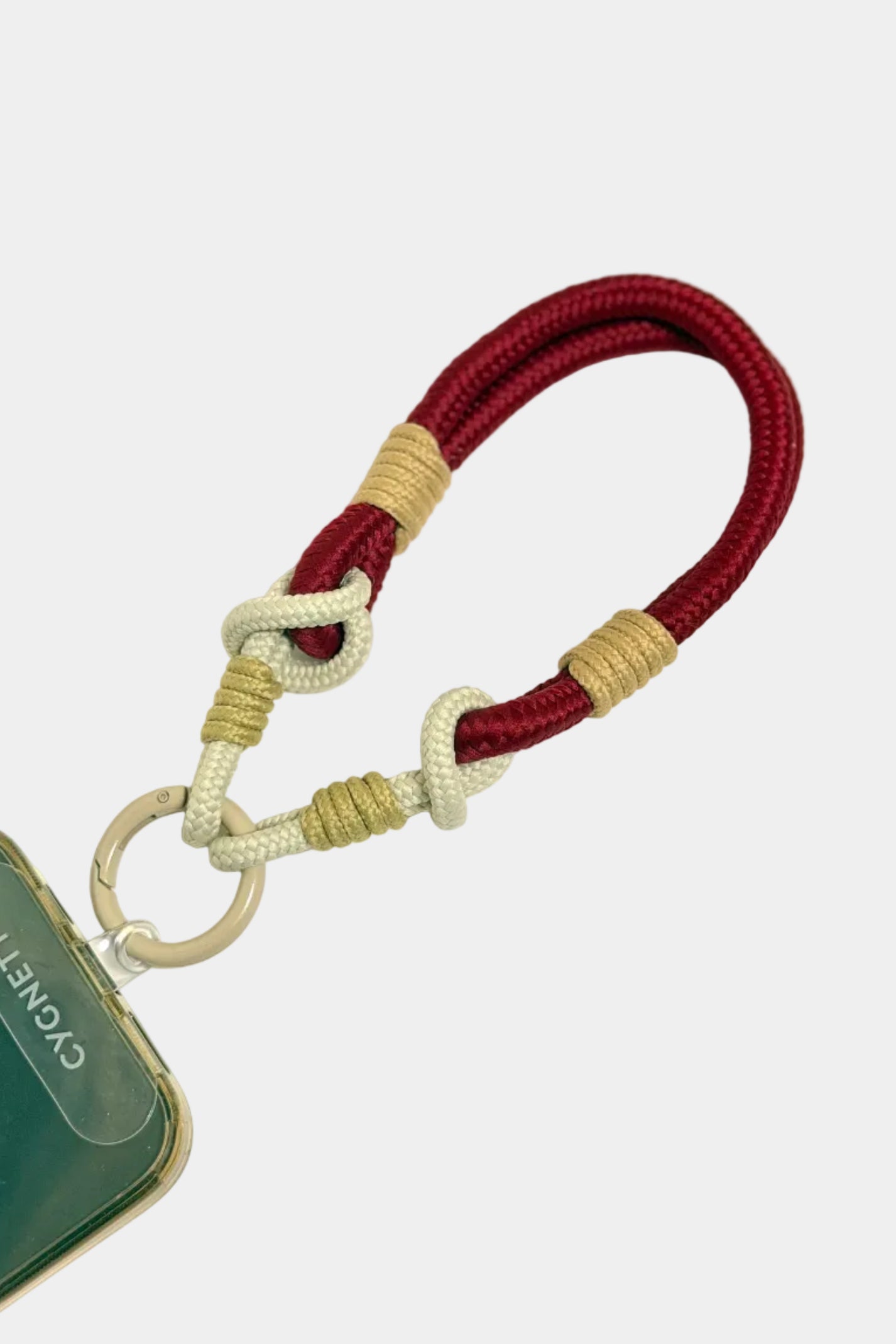 Maroon and beige rope keychain attached to a phone case on a white background