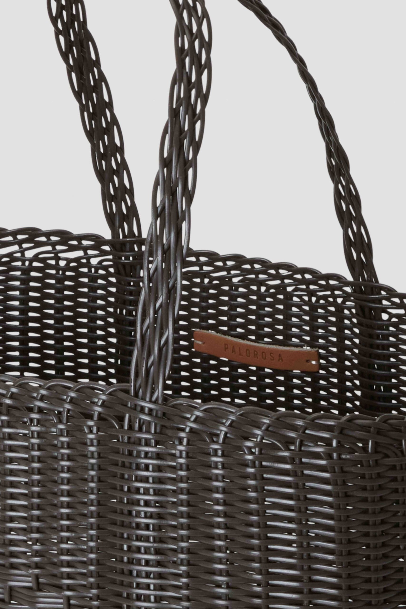 Woven basket with handles on a light gray background