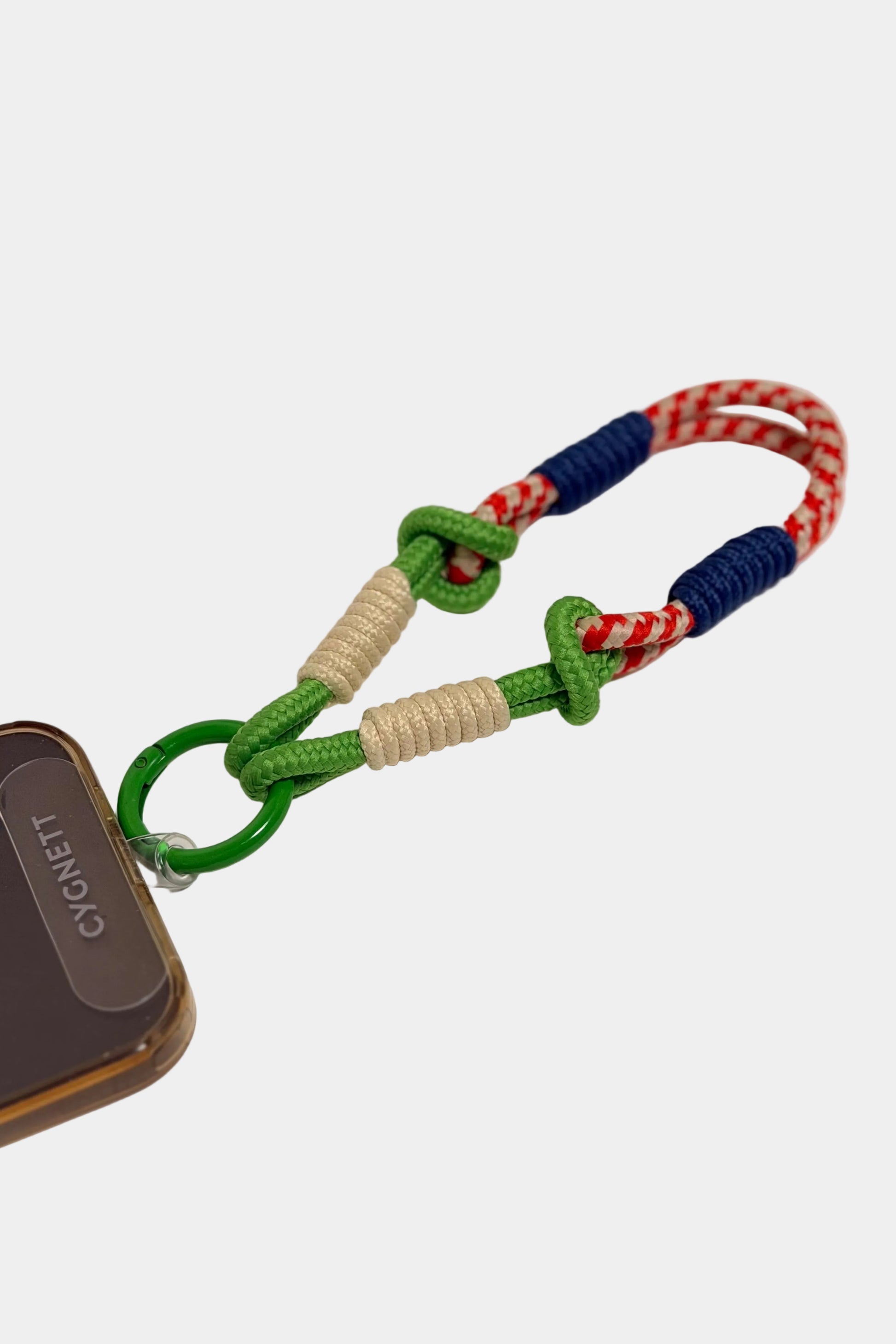 Colorful braided keychain attached to a phone case on a light gray background