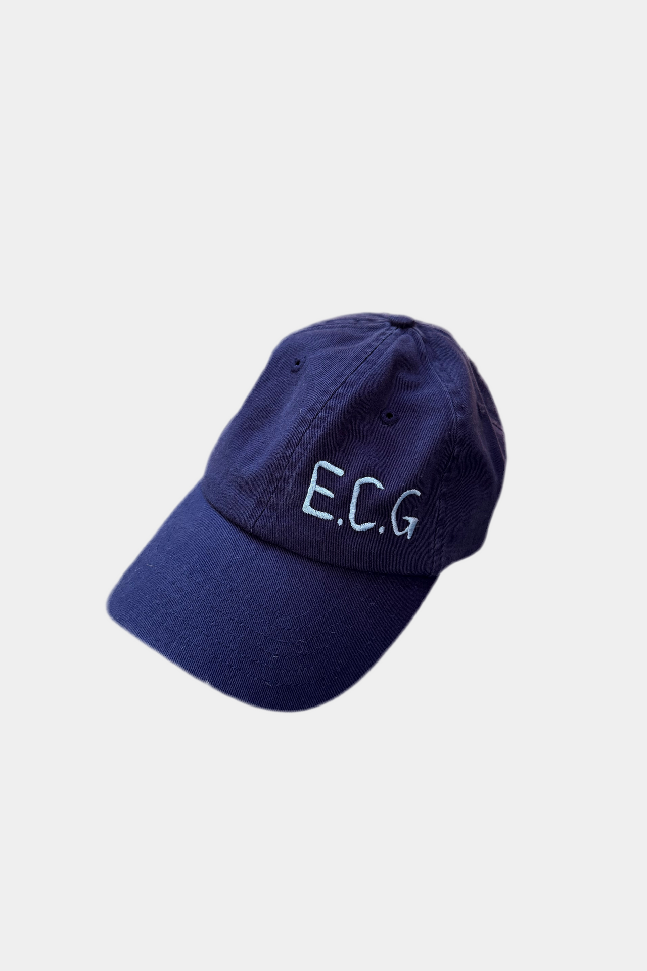 Navy blue cap with 'E.C.G.' text on a light gray background