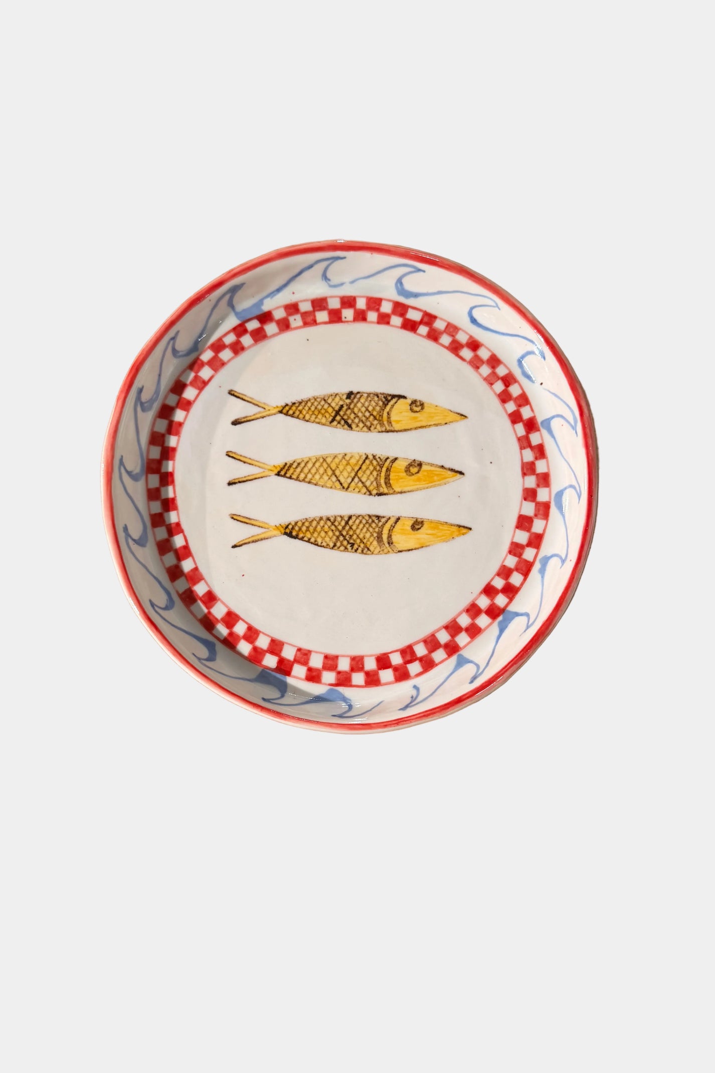 Decorative plate with fish design on a plain surface