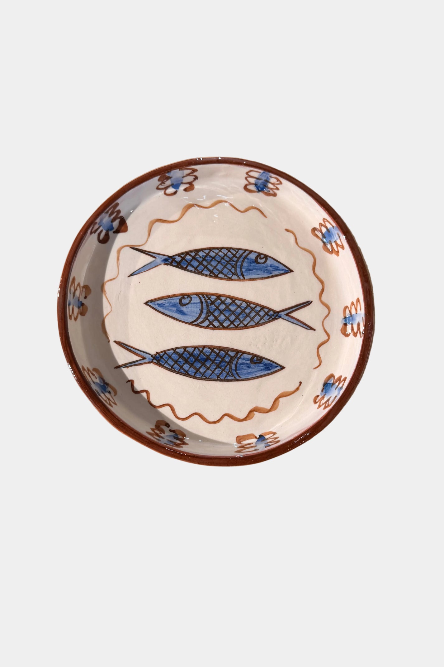 Ceramic plate with fish design on a plain surface