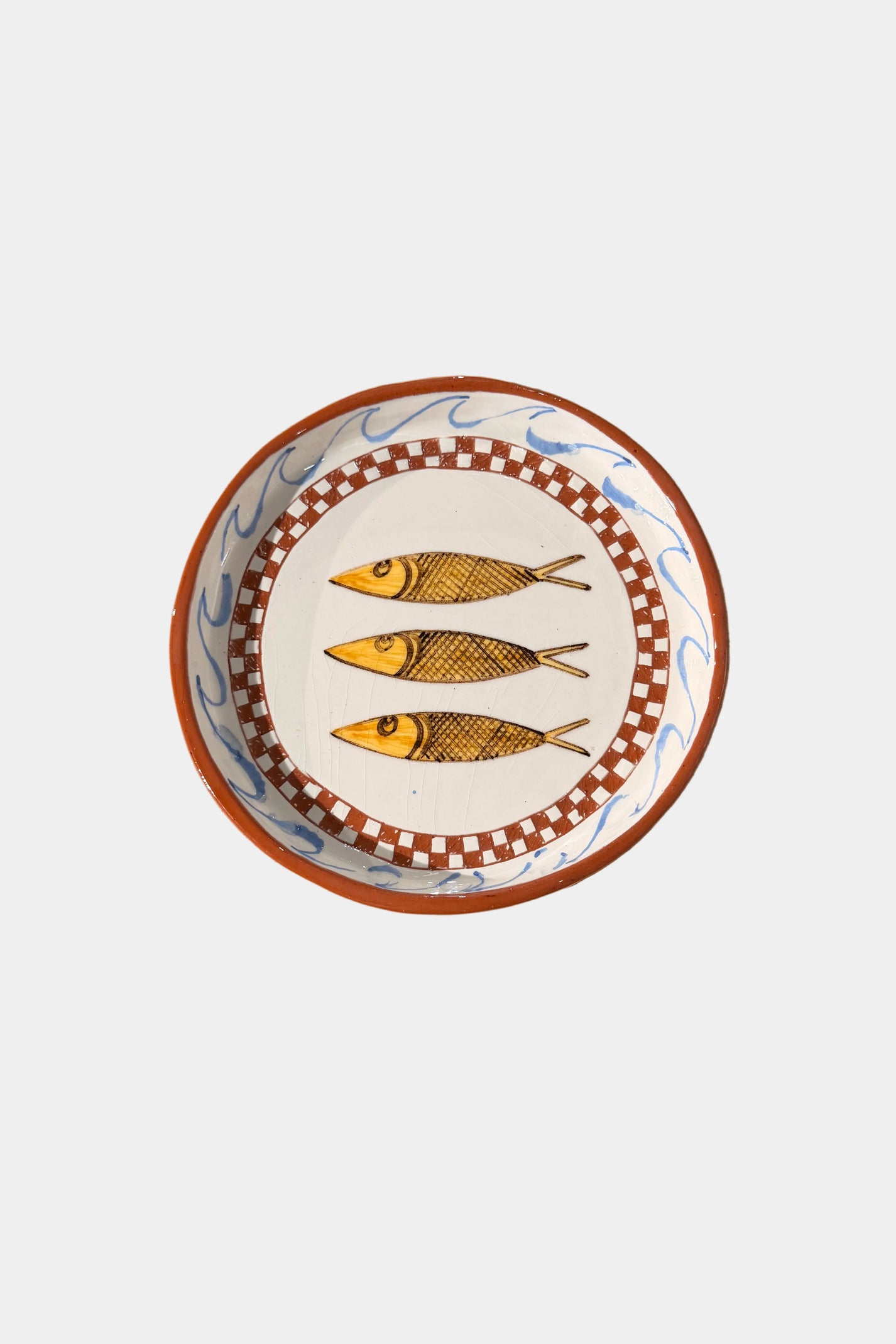 Decorative plate with 3 fish design on a plain surface