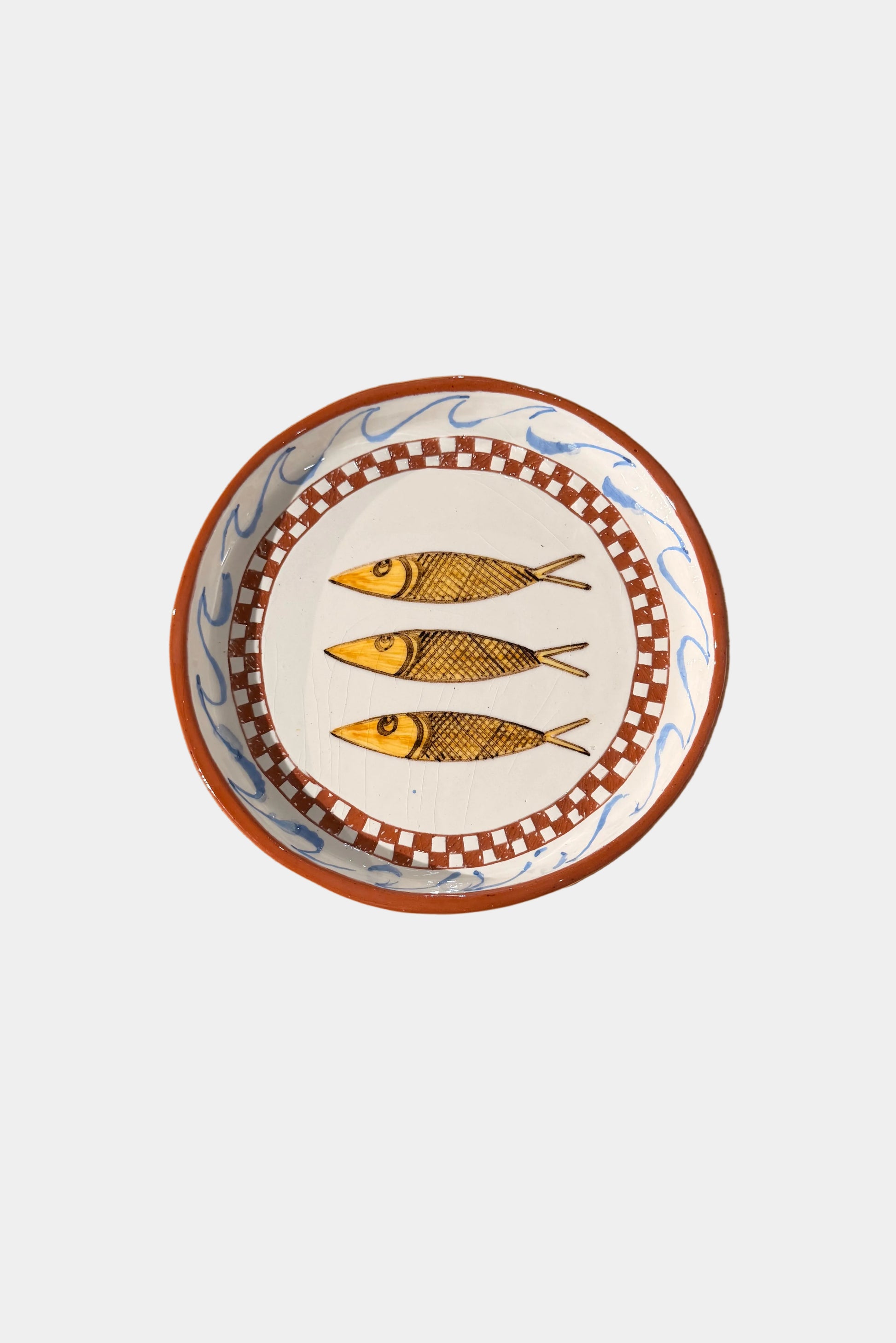 Decorative plate with 3 fish design on a plain surface